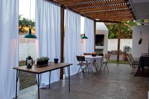 a patio with a table and chairs and a dining room at Barbethuijs in Jeffreys Bay