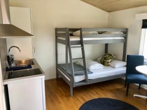 une petite chambre avec des lits superposés et une cuisine dans l'établissement Vättersmålen Stuga, à Gränna