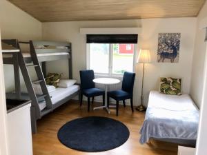 a small room with bunk beds and a table and chairs at Vätterledens Stugrum in Gränna