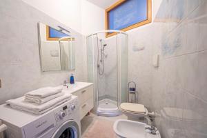 a white bathroom with a shower and a washing machine at Casa Fontanini in Rome