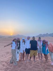 a group of people standing in the desert at Zarb Desert Camp in Wadi Rum