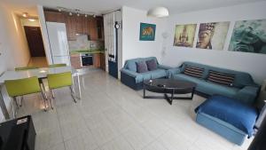 a living room with a blue couch and a table at Acogedor Apartamento Residencial in Costa Teguise +10 photos