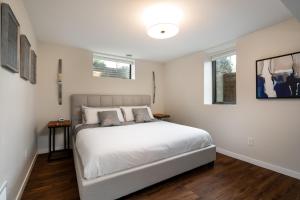 - une chambre blanche avec un lit et 2 fenêtres dans l'établissement Bassett Creek Retreat, à Minneapolis
