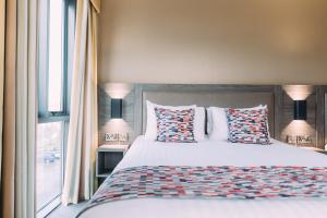 una camera da letto con letto, cuscini e finestra di Armagh City Hotel ad Armagh