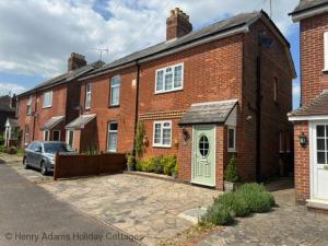 a brick house with a car parked in front of it at Sparrow Cottage - Westbourne in Westbourne