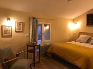 a bedroom with a bed and a table and a window at Hôtel Restaurant L’Observatoire in Saint-Michel-lʼObservatoire