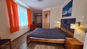 ブワディスワボボにあるPokoje Gościnne Sterのベッドルーム(ベッド1台、オレンジ色のカーテン付)