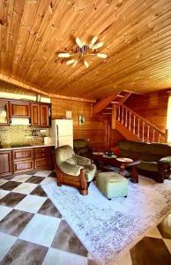 a living room with a wooden ceiling and a checkered floor at VillaSun in Baloži +48 photos