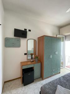 里米尼的住宿－Hotel Haway，一间卧室配有绿色的橱柜和镜子