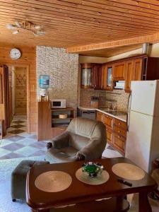 a kitchen with a table and a chair and a refrigerator at VillaSun in Baloži