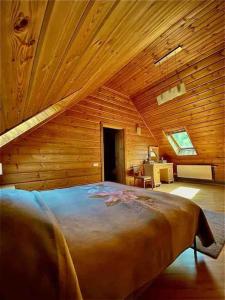 ein Schlafzimmer mit einem großen Bett in einer Holzhütte in der Unterkunft VillaSun in Baloži