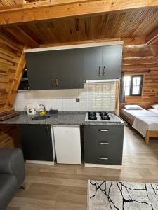 eine Küche mit Herd und ein Bett in einem Zimmer in der Unterkunft Lalin Suit Apart Bungalow in Kumluca