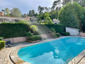 una grande piscina blu in un cortile di Notre Dame des Anges DUPLEX a Rustrel