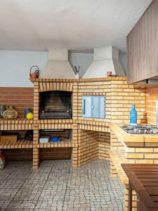 un modelo de cocina con una pared de ladrillo en Inviting - Villa Mar en Árvore