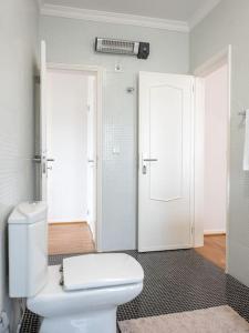 een badkamer met een wit toilet en 2 deuren bij Inviting - Villa Mar in Árvore