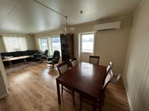 Enesi holiday house : غرفة معيشة مع طاولة وكراسي خشبية