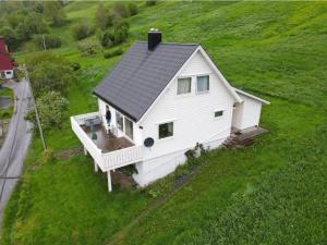 a white house on top of a green field at Enesi holiday house 