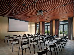 a conference room with chairs and a projection screen at Stradom House, Autograph Collection in Krakow