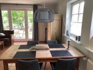 a dining room table with chairs and a pendant light at Appartment Düne in Westerland