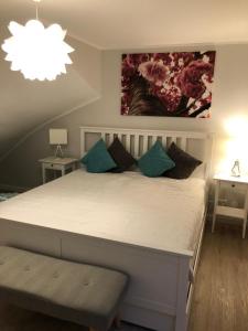 a bedroom with a large white bed with blue pillows at Appartment Düne in Westerland