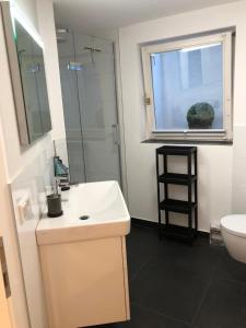 a bathroom with a sink and a toilet and a window at Appartment Düne in Westerland