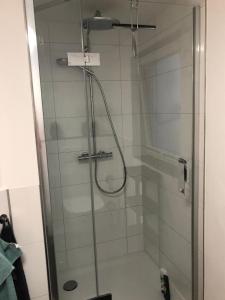 a shower with a glass door in a bathroom at Appartment Düne in Westerland