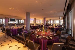 un restaurante con mesas y sillas de color púrpura y TV en W Dallas - Victory, en Dallas