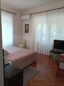 a bedroom with a bed and a desk and a window at Villas Arbia - Rio by the Beach in Rab