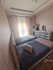 1 dormitorio con 2 camas y ventana en Appartement paisible Haut FOUNTY, en Agadir