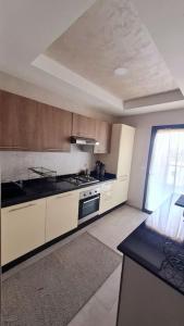 cocina con armarios blancos y fogones en Appartement paisible Haut FOUNTY, en Agadir