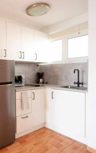 eine Küche mit weißen Schränken und einem Kühlschrank aus Edelstahl in der Unterkunft Apartamento Maypa 2 Salitre in Meloneras