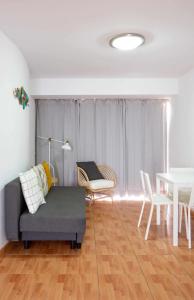 een woonkamer met een bank, stoelen en een tafel bij Apartamento Maypa 2 Salitre in Meloneras