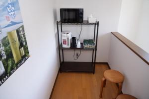 a room with a staircase with a stool and a microwave at Shimanoyado Kamuirishiri in Rishirifuji
