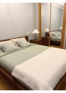 a bedroom with a large bed and a mirror at Gran vía in Ribadeo +9 photos