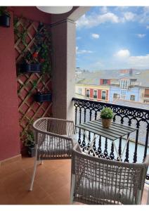 a table and two chairs on a balcony with a view at Gran vía in Ribadeo +9 photos