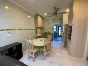 a kitchen and dining room with a table and chairs at Happiness Homestay in Mersing