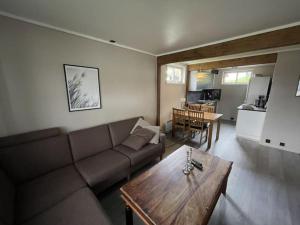 un soggiorno con divano e tavolo di Koselig leilighet i hytteområde på Gautefall a Drangedal