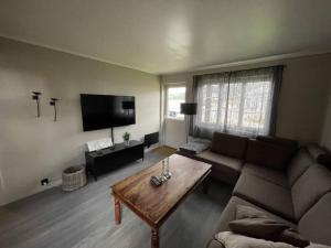 Koselig leilighet i hytteområde på Gautefall في Drangedal: غرفة معيشة مع أريكة وطاولة قهوة