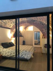 1 dormitorio con cama y pared de ladrillo en Encantadora casa rural Can Vidal, en Espolla