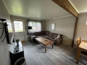Koselig leilighet i hytteområde på Gautefall في Drangedal: غرفة معيشة مع أريكة وطاولة