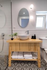 een badkamer met een wastafel en een spiegel bij Avali Design Suites by Imagine Lefkada in Lefkada
