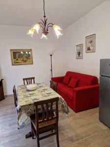 salon z czerwoną kanapą i stołem w obiekcie Appartamento Filomena scano di montiferro w mieście Scano Montiferro