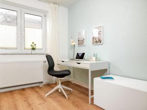 um quarto branco com uma secretária e uma cadeira em Haffblick em Insel Poel
