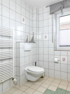 uma casa de banho branca com um WC e uma janela em Haffblick em Insel Poel