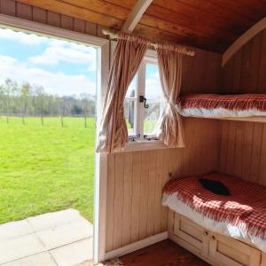 um quarto com 2 beliches e uma janela em Skylark Shepherds Hut em Royal Tunbridge Wells