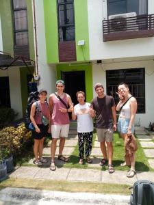 a group of people standing outside of a building at Haus of Emerald by JeYo in Mactan