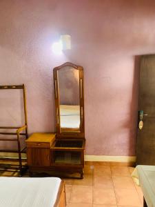 een spiegel op een dressoir naast een bed bij Hareesha Holiday Resort in Galle