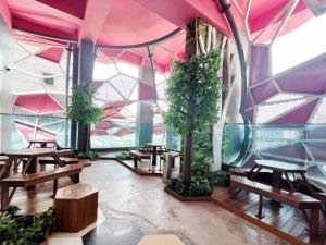 uma sala com mesas e árvores e tectos cor-de-rosa em Arte Plus Ampang By The Relax Stay Kualalumpur em Kuala Lumpur