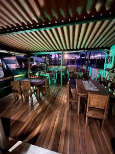 un restaurante con mesas de madera y sillas en una terraza en Chalés Alto Da Estância en Alto Paraíso de Goiás