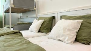1 Schlafzimmer mit 2 Betten und grünen Kissen in der Unterkunft Mali Schachmuseum in Klagenfurt am Wörthersee